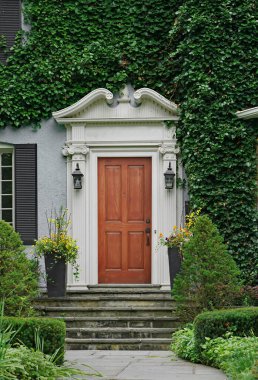  Evin ahşap ön kapısı sarmaşıklarla çevrili.