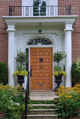 Evin ahşap ön kapısı, zarif giriş kapısı ve çiçekleri var.