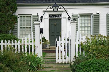 Küçük beyaz tuğlalı evin ön kapısı.