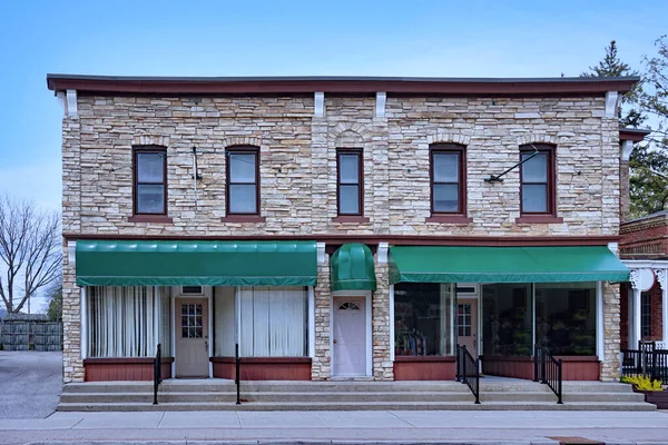 Zemin katında mağazaları ve üst katında daireleri olan küçük bir bina.