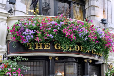 Exterior of traditional London pub with cheerful floral decorations