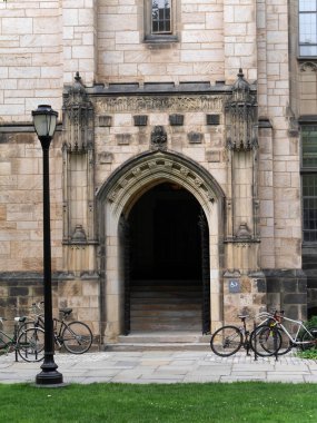 Park halindeki bisikletlerle Gotik tarzı üniversite binası girişi