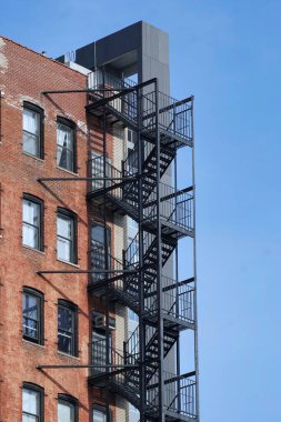 Harici merdivenleri olan eski bir apartman.