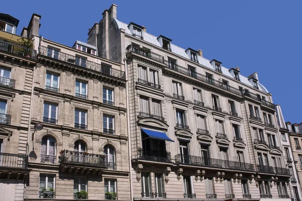 Paris, elegant apartment buildings with casement windows and louvered French doors opening onto balconies