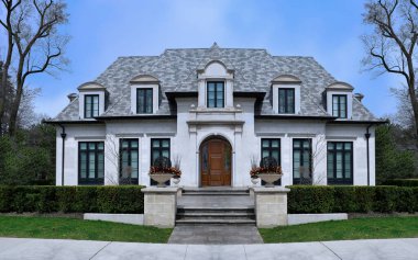 Devamlı yeşil çitleri ve yatakhane pencereleri olan büyük, zarif bir ev.