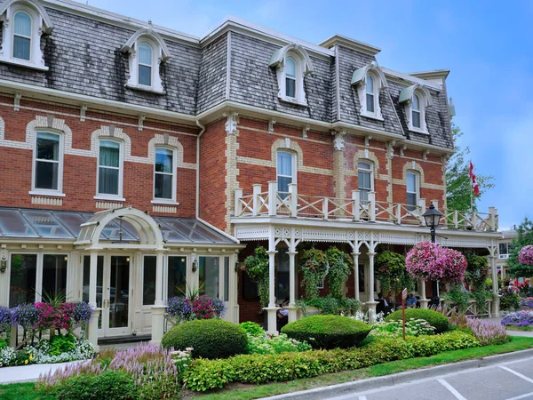 Old brick building with restaurant and floral decorations on the street