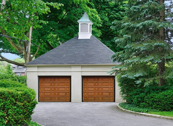 Detached residential garage surrounded by trees