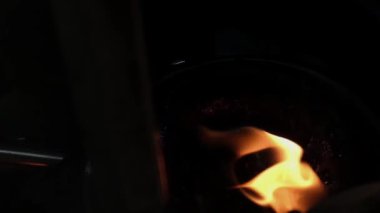 A fire flame burns in an oil pot. metal construction around, or steel box some beautiful orange reflections in slow motion. High quality FullHD footage, Recorded by Fujifilm XT4