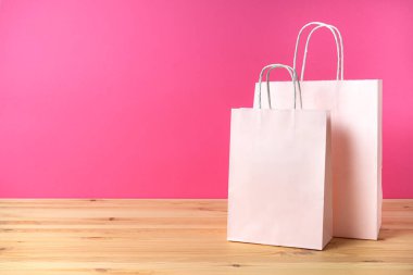 Kağıtlar parlak pembe bir arka planda, mesaj için yer var. Tatil için başarılı bir alışveriş..