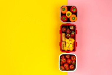 İçinde kurabiye, peynir, çilek, domates ve biber olan yemek kutuları. Sağlıklı atıştırmalık konsepti. Üst görünüm