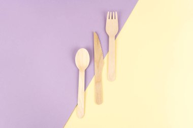 Renkli arka planlarda eko cihazlar. Bambu kaşığı, çatal ve bıçak, üst manzara.