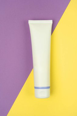 El kremi, nemlendirici, diş macunu, leylak kaplı losyon kavanozu plastik tüp ve sarı arka plan. Spa ambalajı maketi. Dikey fotoğraf