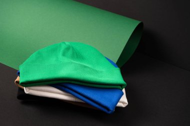 Farklı renklerde, mavi, siyah, beyaz ve yeşil bereler. Sıra dışı koyu bir arka planda istiflenmiş. Yerleşim için hazır