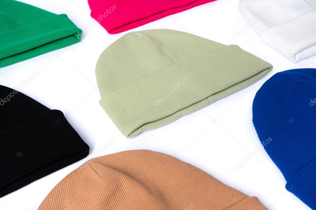 Stylish youth beanie hats, winter collection of bright colors laid out on a white background side view
