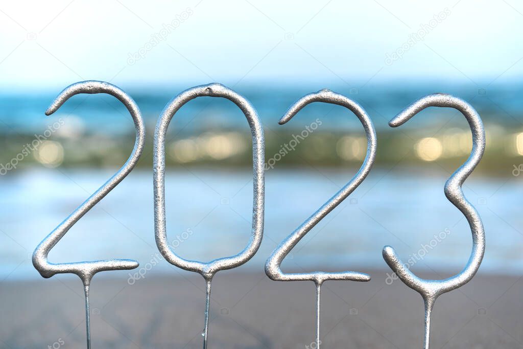 The numbers for the coming New Year 2023 amid waves on the beach. New year celebration concept in exotic country. Close up