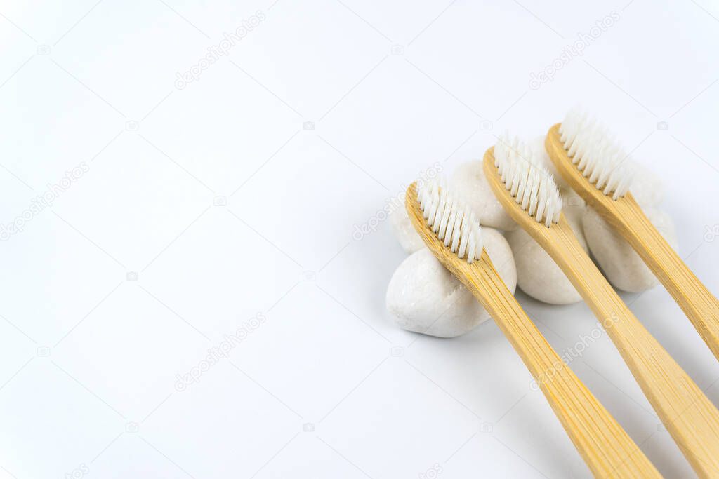 Bamboo toothbrushes on white stone with copy space. Eco dental concept. Close up view of organic bamboo toothbrushes