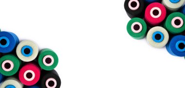 Kopya alanı olan beyaz bir arkaplan üzerindeki renkli iplik makaralarının üst görünümü.