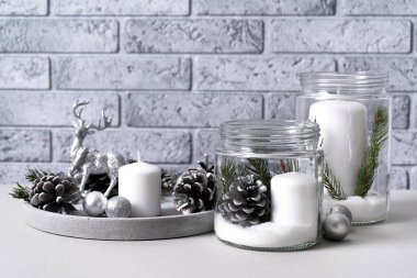 Cam kavanozda mumlar, çimento tepside mumlar, çam kozalakları, köknar dalları ve siyah arka planda bir geyik olan gümüş Noel toplarıyla Noel için.. 