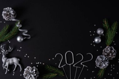 Gümüş geyik, kozalak, noel balosu ve köknar dalıyla 2022 yılının rakamları. Kopyalama alanı olan gümüş düz düzen.