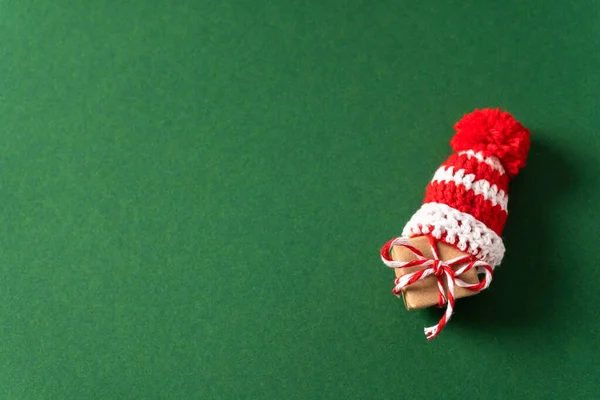 Kleines Geschenk Mit Roter Weihnachtsmütze Auf Grünem Hintergrund Mit Kopierraum — Stockfoto