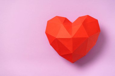 Sevgililer Günü için pembe arka planda kırmızı çokgen kağıt kalp. El ilanları, davetiyeler, afişler, tebrik kartları için uygun. Boşluğu kopyala