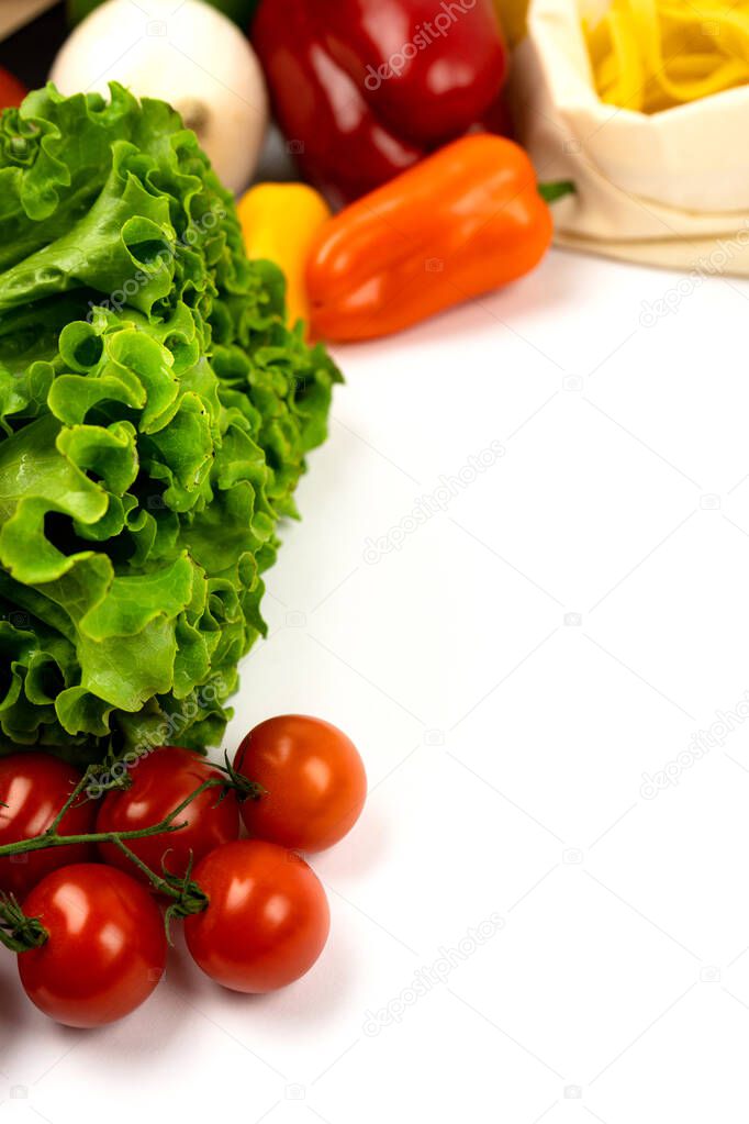 Fresh colorful organic vegetables on a white background, Vertical photo. Copy space. 