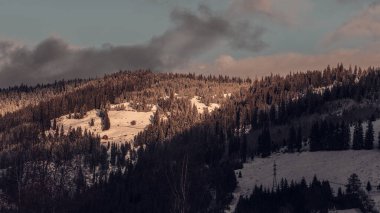 Kış, yüksek dağlarda kar beyazı zirveler. Yeri Carpathian, Vatra Dornei, Bucovina, Suceava, Romanya, Avrupa. Günbatımı. Kış ormanı Misafir evi