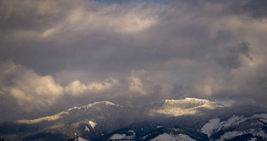 Kış, yüksek dağlarda kar beyazı zirveler. Yeri Carpathian, Vatra Dornei, Bucovina, Suceava, Romanya, Avrupa. Günbatımı. Kış ormanı Misafir evi