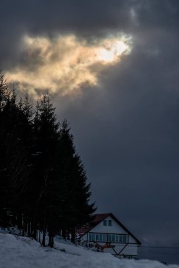 Kış, yüksek dağlarda kar beyazı zirveler. Yeri Carpathian, Vatra Dornei, Bucovina, Suceava, Romanya, Avrupa. Günbatımı. Kış ormanı Misafir evi