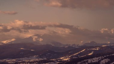 Kış, yüksek dağlarda kar beyazı zirveler. Yeri Carpathian, Vatra Dornei, Bucovina, Suceava, Romanya, Avrupa. Günbatımı. Kış ormanı Misafir evi