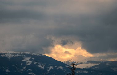 Kış, yüksek dağlarda kar beyazı zirveler. Yeri Carpathian, Vatra Dornei, Bucovina, Suceava, Romanya, Avrupa. Günbatımı. Kış ormanı Misafir evi