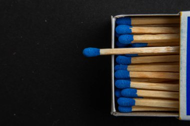 Siyah arka planda mavi ahşap kibrit. Parlak mavi başlı kibrit çöpleri makro. Yakından bakmadan saçılmış ahşap kibritler. Sigara içen aksesuar konsepti için tasarım elemanı. Üst görünüm.