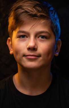 Stüdyoda gülümseyen yakışıklı bir çocuğun portresi, mavi gözlü bir çocuğun portresi.