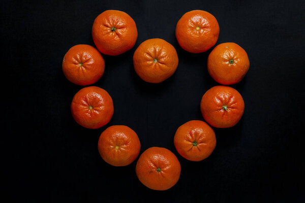 fresh orange and black tangerines on a dark background.