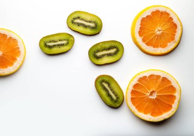 Dilimlenmiş greyfurt, beyaz arka planda yarı izole edilmiş. Pembe, portakallı taze greyfurt narenciye, zevkle dilimlenmiş, dramatik ışık dokusu, arka planda renkli dilimlenmiş meyveler ışıklandırılmış, kopyalama alanı