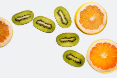 Dilimlenmiş greyfurt, beyaz arka planda yarı izole edilmiş. Pembe, portakallı taze greyfurt narenciye, zevkle dilimlenmiş, dramatik ışık dokusu, arka planda renkli dilimlenmiş meyveler ışıklandırılmış, kopyalama alanı