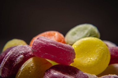 Renkli tatlı kaynamış tatlılar, şekerler, beyaz üzerine şeker, siyah arka plan, sert şeker