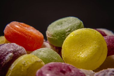 Renkli tatlı kaynamış tatlılar, şekerler, beyaz üzerine şeker, siyah arka plan, sert şeker