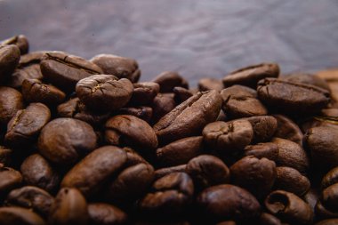 Kahve çekirdeği. Kahve çekirdekleri yüzeyde yayılır. Kavrulmuş kahve çekirdeği arka planı, desen