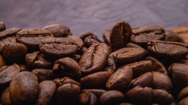 Kahve çekirdeği. Kahve çekirdekleri yüzeyde yayılır. Kavrulmuş kahve çekirdeği arka planı, desen