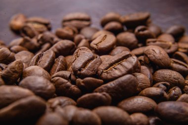 Kahve çekirdeği. Kahve çekirdekleri yüzeyde yayılır. Kavrulmuş kahve çekirdeği arka planı, desen