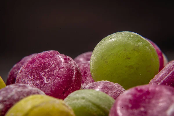 Renkli tatlı kaynamış tatlılar, şekerler, beyaz üzerine şeker, siyah arka plan, sert şeker