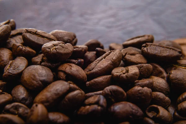 Kahve çekirdeği. Kahve çekirdekleri yüzeyde yayılır. Kavrulmuş kahve çekirdeği arka planı, desen
