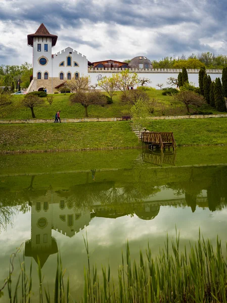 stock image Purcari, Moldova 27.04.2022. Modern winery Chateau Purcari in Purcari village, Moldova, on a clody spring day, Greenery, wooden bridge, lake, logo, white swan, belvedere, vineyard,