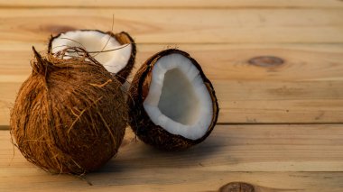 Olgun bir delik ve eski ahşap bir arka planda yarım hindistan cevizi. Hindistan cevizi kreması ve yağ..