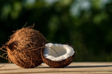 Olgun bir delik ve eski ahşap bir arka planda yarım hindistan cevizi. Hindistan cevizi kreması ve yağ..