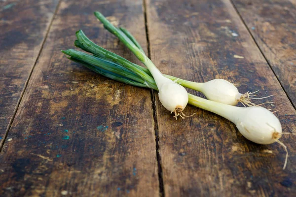 bunch of spring onions on  old board wood, Onion seeds and seed head,  white and yellow , concept, top view