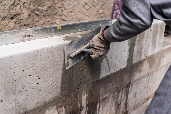 男はコンクリートブロックを構築します新しいシリーズの建設に使用されるレンガが人気がありますコンクリートブロック 簡単な建設 石膏カット — ストック写真