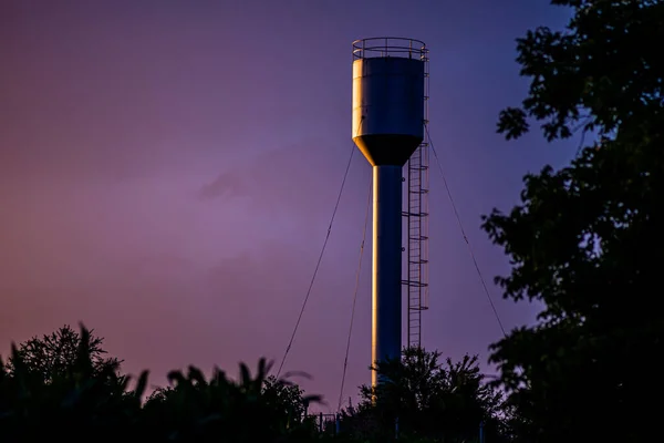 A large  Old Stainless Water Tank With Water Pump In The countryside at sunset, bluehour, To reserve water when the water supply does not flow