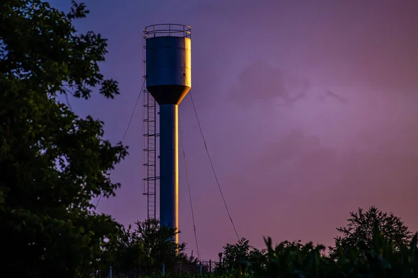 A large  Old Stainless Water Tank With Water Pump In The countryside at sunset, bluehour, To reserve water when the water supply does not flow
